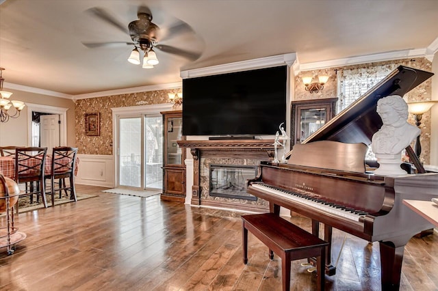 misc room featuring hardwood / wood-style floors, ceiling fan with notable chandelier, and ornamental molding