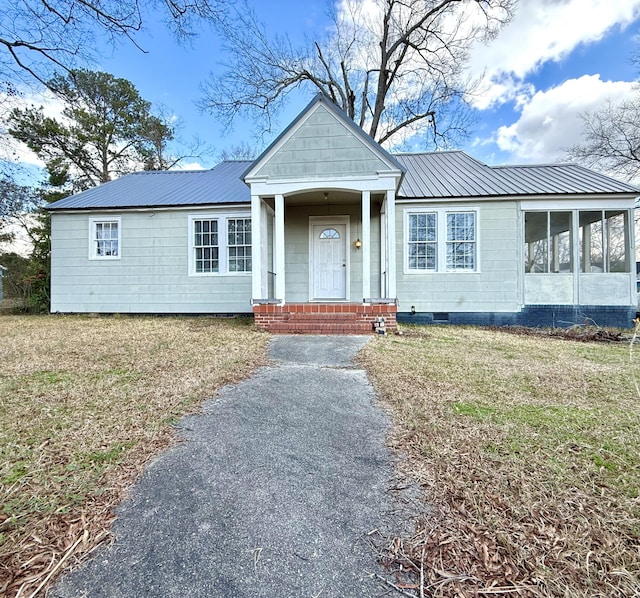 view of front of home with a front yard and a sunroom