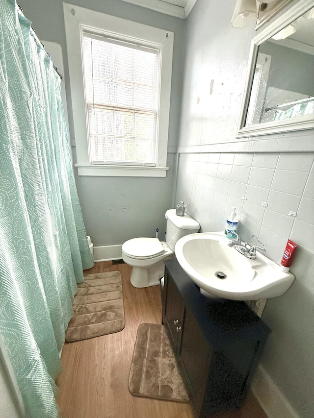 bathroom featuring vanity, hardwood / wood-style floors, tile walls, and toilet