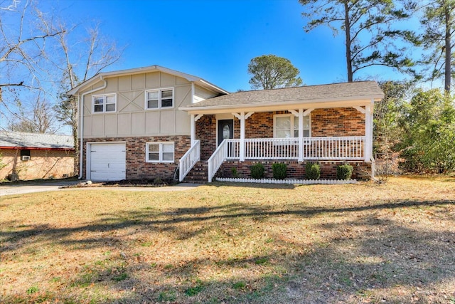 split level home featuring covered porch, a front yard, and a garage