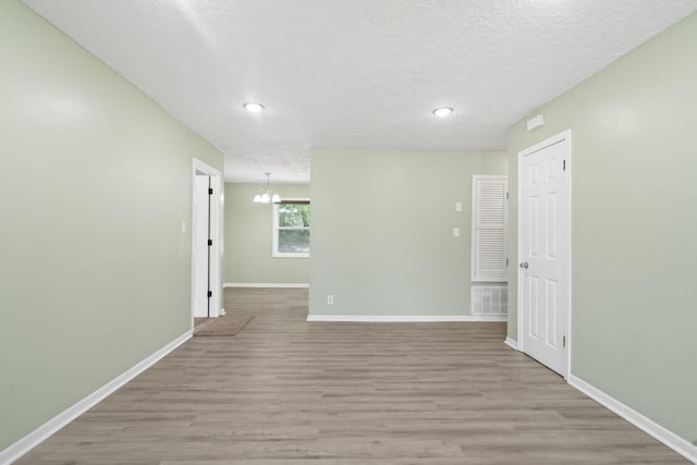 2954 Celeste Dr, Hephzibah, GA 30815 - empty room featuring wood finished floors, baseboards, recessed lighting, a textured ceiling, and a chandelier