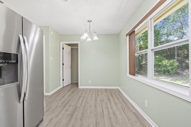 2954 Celeste Dr, Hephzibah, GA 30815 - unfurnished dining area featuring light wood-style flooring, healthy amount of natural light, a chandelier, baseboards, and a textured ceiling