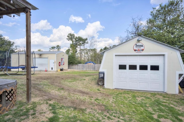 garage featuring a trampoline and a yard