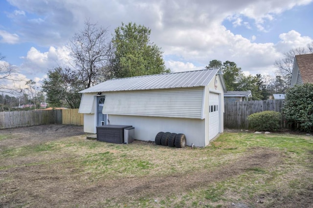 exterior space featuring a garage, an outdoor structure, and a lawn