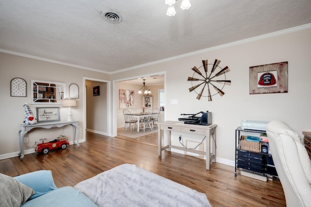 living room with hardwood / wood-style floors, a textured ceiling, ornamental molding, and a chandelier