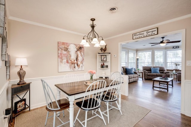 dining room featuring crown molding, wood-type flooring, and a notable chandelier