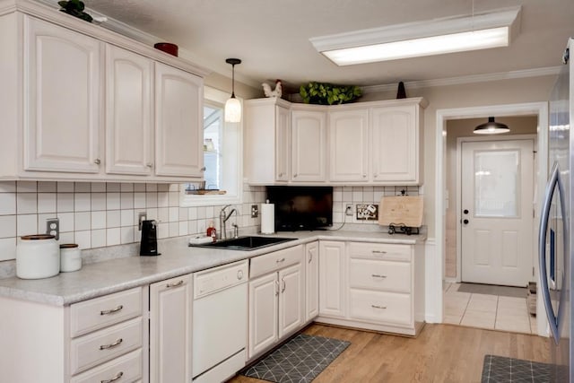 kitchen with sink, white cabinetry, hanging light fixtures, stainless steel fridge, and white dishwasher