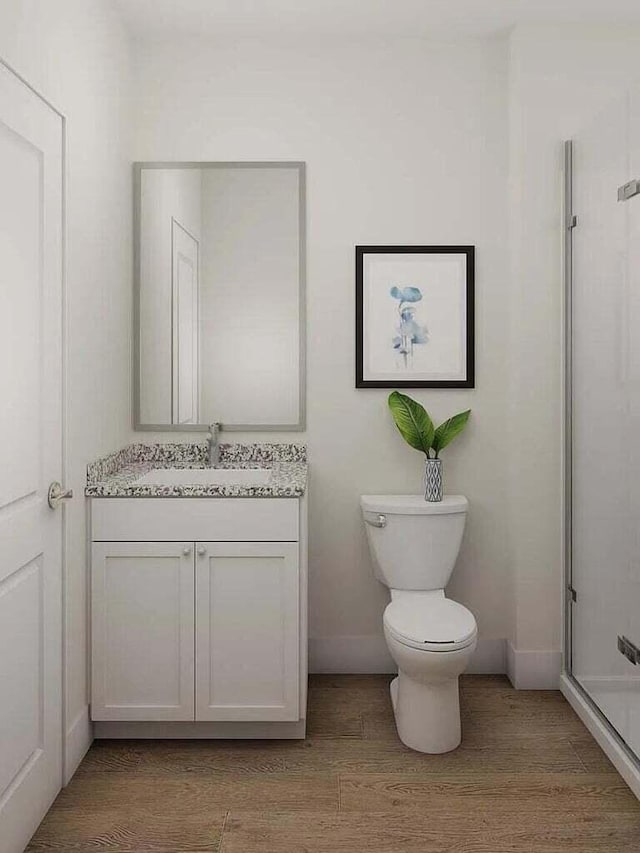 bathroom with vanity, hardwood / wood-style flooring, toilet, and an enclosed shower