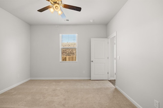 spare room with ceiling fan and light colored carpet