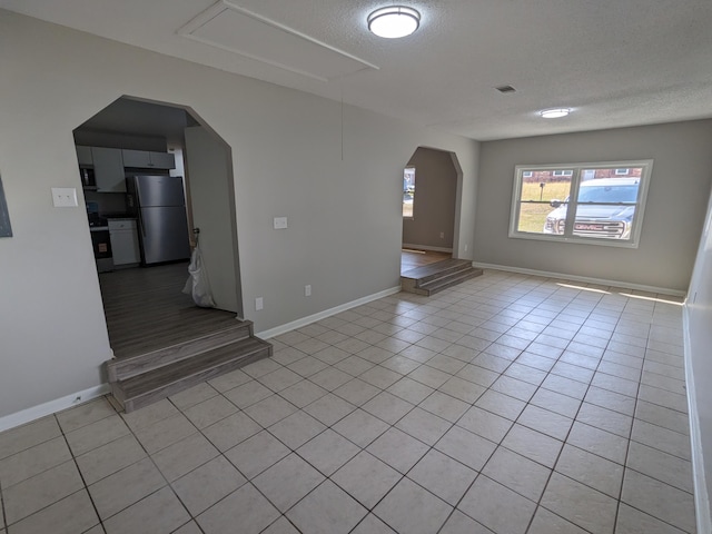 3332 Hillis Rd, Augusta, GA 30906 - empty room with arched walkways, light tile patterned floors, a textured ceiling, and baseboards