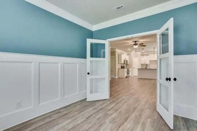 1068 Burlington Dr, Augusta, GA 30909 - unfurnished room with french doors, a decorative wall, a wainscoted wall, crown molding, and wood finished floors