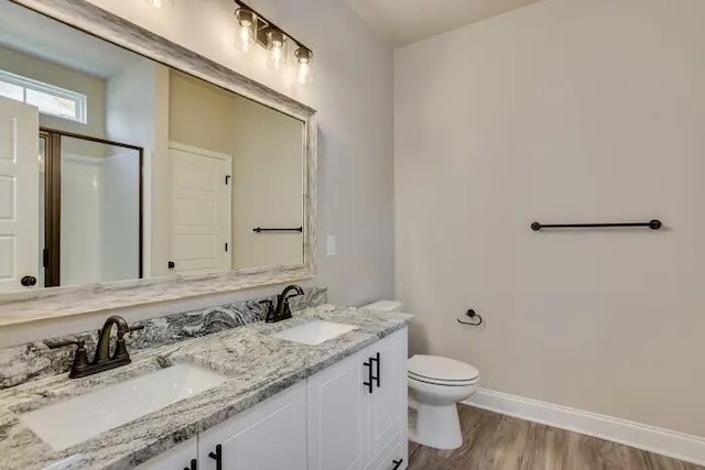 1068 Burlington Dr, Augusta, GA 30909 - bathroom with baseboards, toilet, wood finished floors, double vanity, and a shower with door