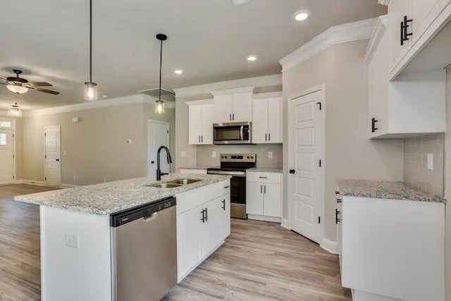 1068 Burlington Dr, Augusta, GA 30909 - kitchen featuring appliances with stainless steel finishes, a sink, ornamental molding, light wood-style flooring, and white cabinetry