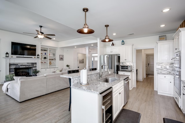 210 Rivernorth Dr, North Augusta, SC 29841 - kitchen with stainless steel appliances, wine cooler, open floor plan, ceiling fan, and white cabinetry