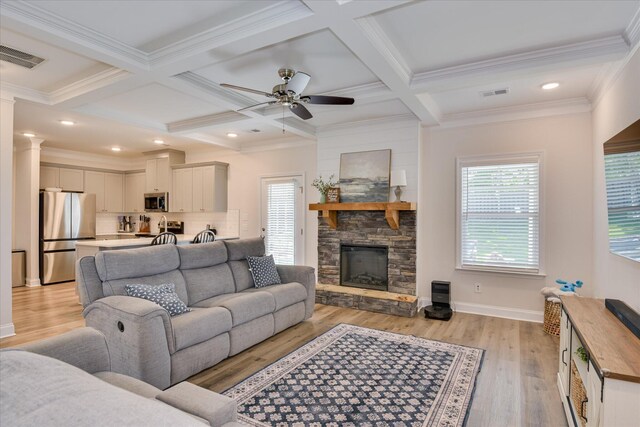 living area with a healthy amount of sunlight, light wood-style flooring, and visible vents