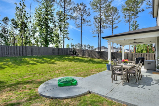 view of yard with a fenced backyard, a ceiling fan, a patio, and outdoor dining area
