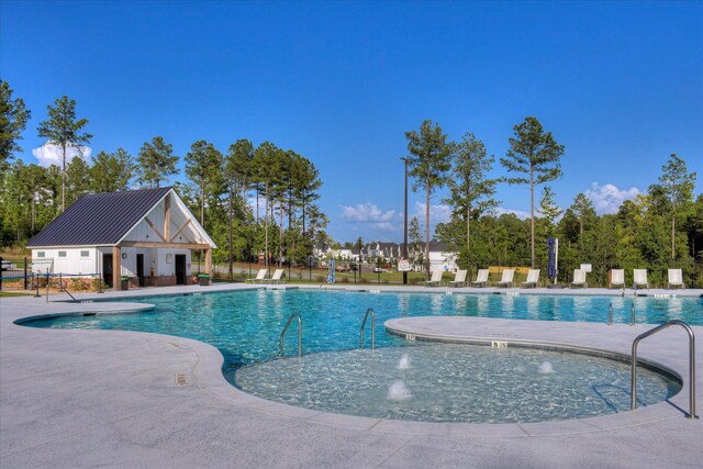 pool with a patio area and fence