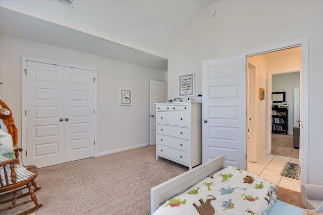 bedroom with visible vents, vaulted ceiling, baseboards, a closet, and light carpet