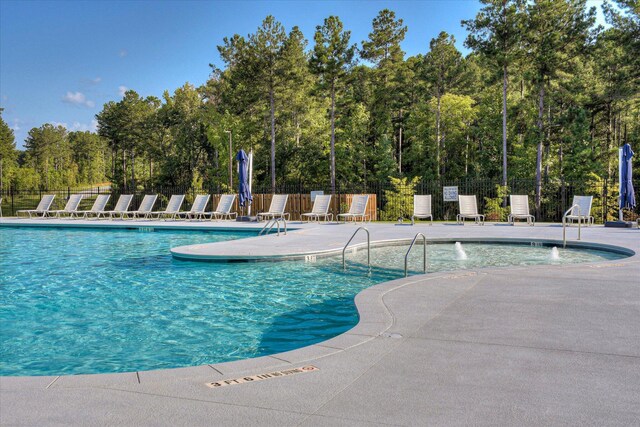 pool featuring fence and a patio