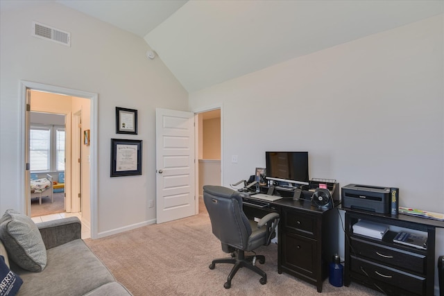 home office featuring baseboards, lofted ceiling, light colored carpet, and visible vents
