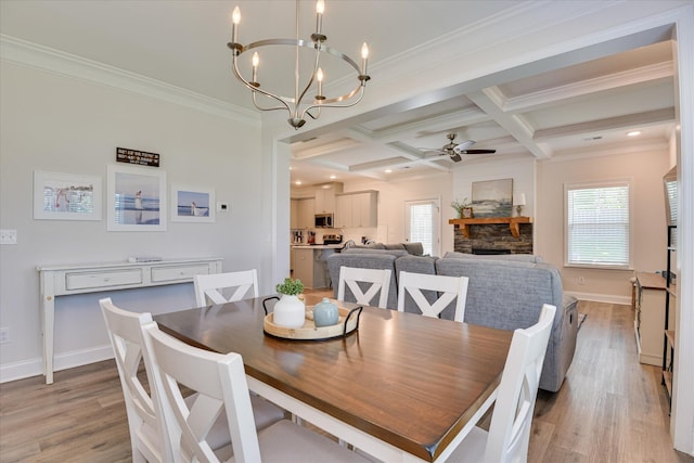dining space with beamed ceiling, ceiling fan with notable chandelier, light wood finished floors, and coffered ceiling