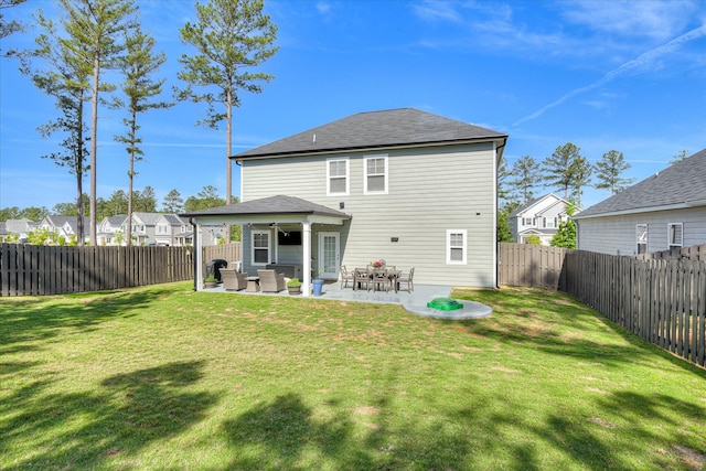 back of property with a lawn, a patio, and a fenced backyard