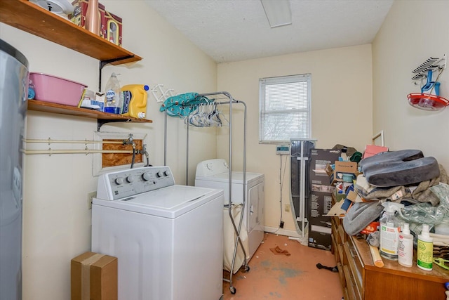 clothes washing area with separate washer and dryer and a textured ceiling