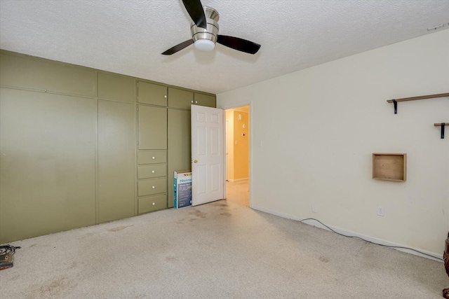 unfurnished bedroom with light carpet, a textured ceiling, and ceiling fan