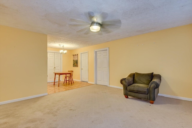 living area featuring an inviting chandelier, light colored carpet, and a textured ceiling