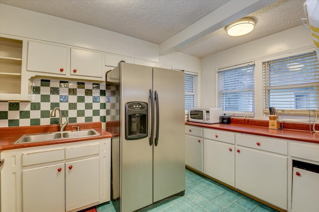 kitchen with stainless steel fridge with ice dispenser, backsplash, sink, and white cabinets