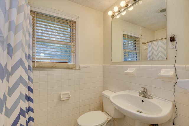 bathroom featuring sink, tile walls, a textured ceiling, and toilet