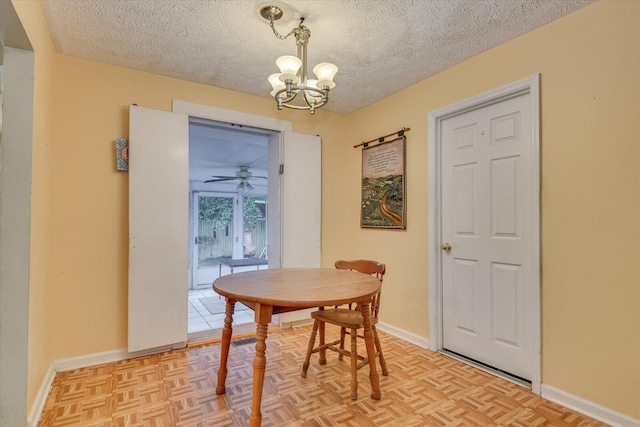 dining area with light parquet flooring, a chandelier, and a textured ceiling