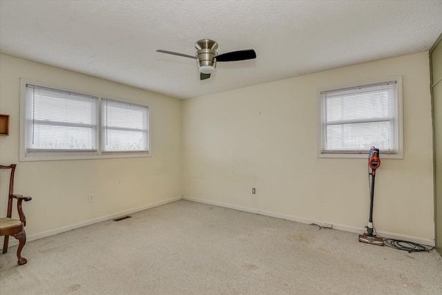 unfurnished room with ceiling fan and a textured ceiling