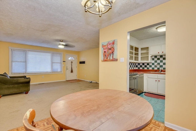 dining area featuring sink, a textured ceiling, and a notable chandelier