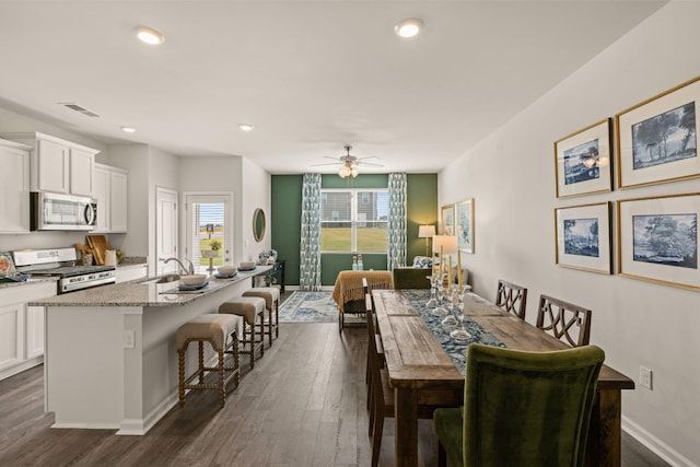 dining space featuring ceiling fan and dark wood-type flooring