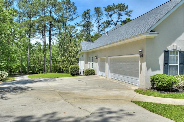 327 Peter Carnes Dr, North Augusta, SC 29860 - view of side of property featuring a shingled roof, stucco siding, concrete driveway, and a garage