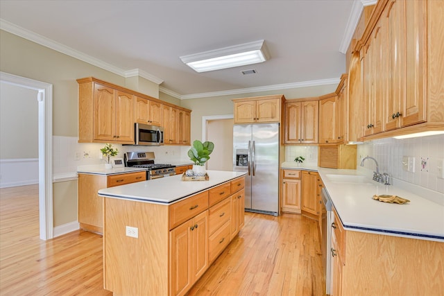 327 Peter Carnes Dr, North Augusta, SC 29860 - kitchen with appliances with stainless steel finishes, light wood-style floors, a center island, crown molding, and a sink