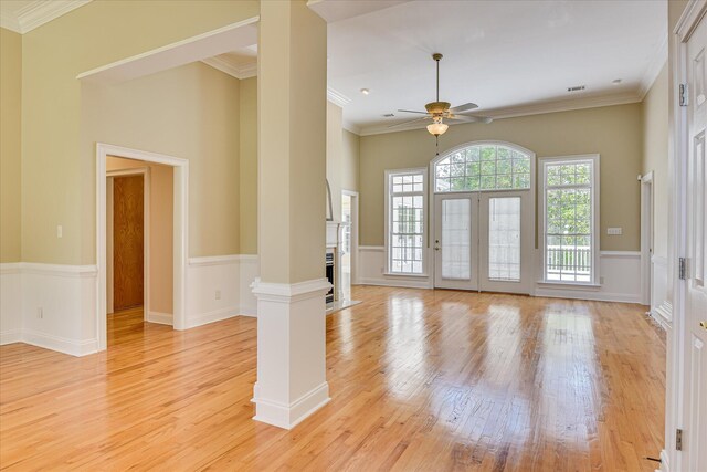 327 Peter Carnes Dr, North Augusta, SC 29860 - unfurnished room featuring light wood-style floors, a ceiling fan, a fireplace with flush hearth, crown molding, and ornate columns
