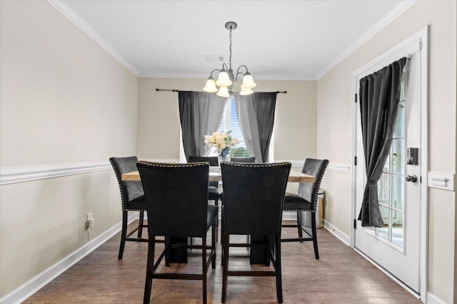 dining area featuring hardwood / wood-style floors, an inviting chandelier, and ornamental molding