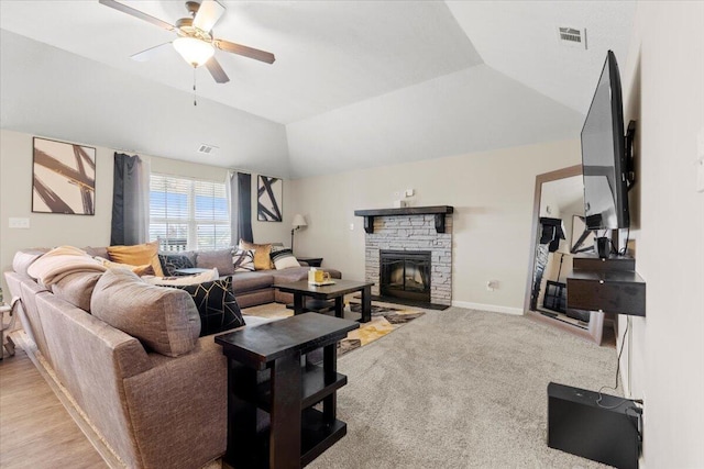 living room featuring a fireplace, a tray ceiling, vaulted ceiling, and ceiling fan