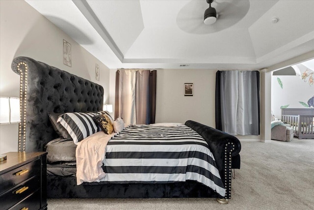 carpeted bedroom with ceiling fan, a raised ceiling, and lofted ceiling