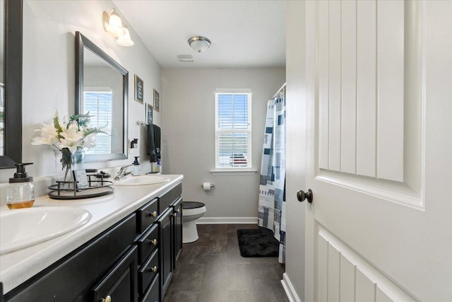 bathroom with vanity, a healthy amount of sunlight, and toilet