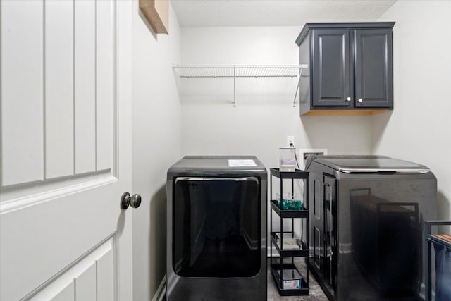 laundry area featuring washer and dryer and cabinets