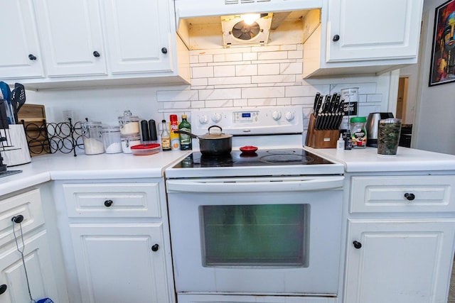 kitchen with white range with electric cooktop, decorative backsplash, white cabinets, and under cabinet range hood