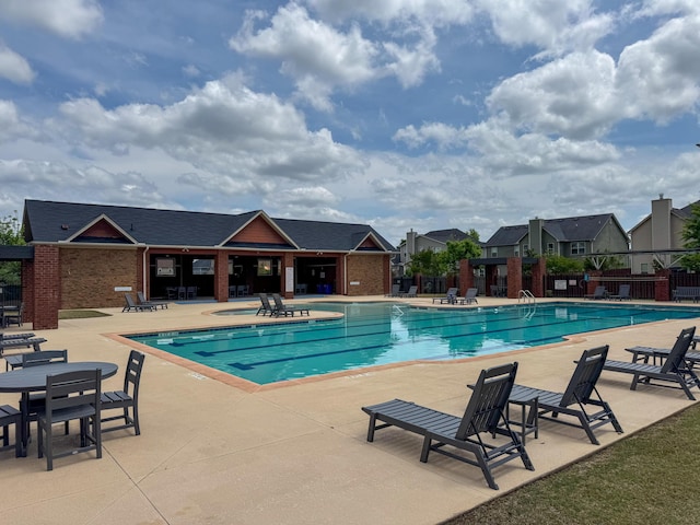 community pool featuring a patio area and fence