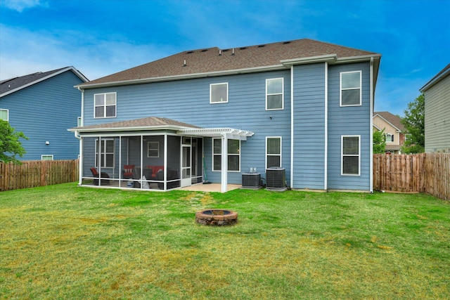rear view of house featuring an outdoor fire pit, central AC unit, a sunroom, and a lawn