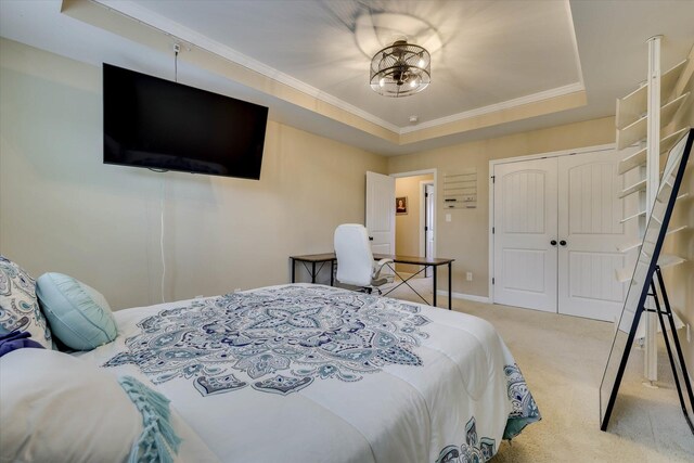 carpeted bedroom featuring crown molding, a closet, a raised ceiling, and baseboards
