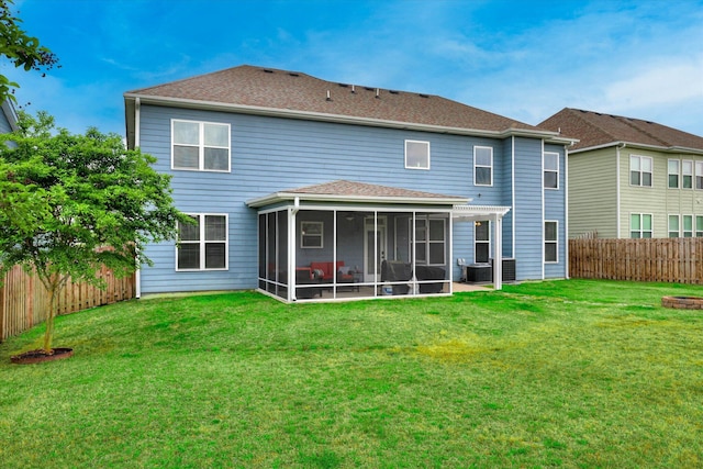 back of property with a sunroom, central air condition unit, a yard, and a fenced backyard