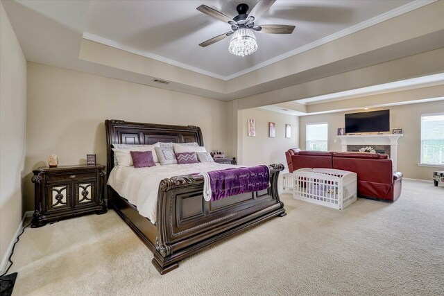 bedroom featuring carpet, ornamental molding, ceiling fan, visible vents, and a raised ceiling