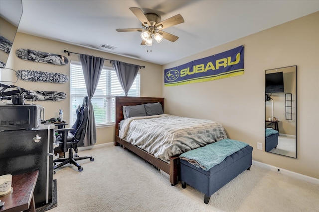 carpeted bedroom with baseboards, visible vents, and ceiling fan